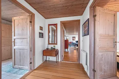 a hallway with wooden doors and a wooden floor at Lovely Holiday House With 4 Rooms Close To The North Sea in Frøstrup
