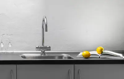 a kitchen sink with a book and two oranges at Beautiful Home In Vestervig With Sauna in Vestervig