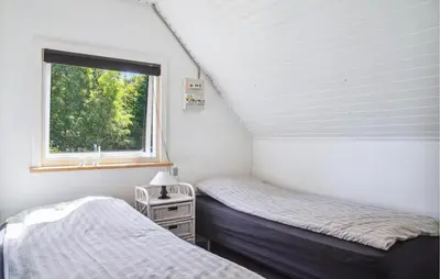 a bedroom with two twin beds and a window at 2 Bedroom Amazing Home In Spøttrup in Spottrup