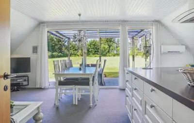 a kitchen with a table and a dining room at 2 Bedroom Amazing Home In Spøttrup in Spottrup