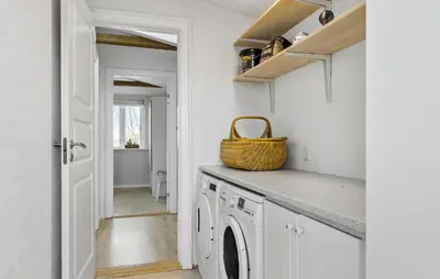 a laundry room with a washing machine and a basket at 3 Bedroom Cozy Home In Nibe in Nibe