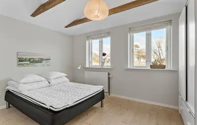 a bedroom with a bed in a room with windows at 3 Bedroom Cozy Home In Nibe in Nibe