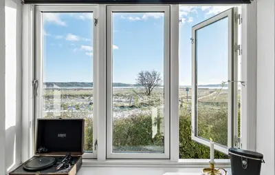 a room with three windows with a computer on a desk at 3 Bedroom Cozy Home In Nibe in Nibe