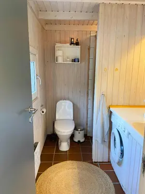 a small bathroom with a toilet and a sink at A Gem In The Woods Close To The North Sea in Rødhus
