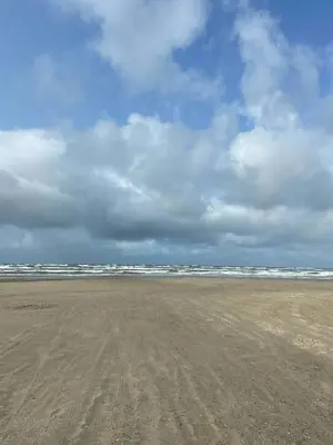 an empty beach with a cloudy sky in the background at A Gem In The Woods Close To The North Sea in Rødhus