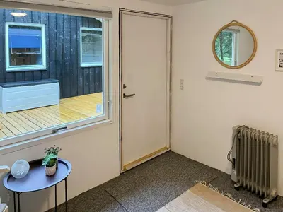 a room with a door and a table and a window at Familievenligt Hus Nær Tranum Klitplantage in Pandrup