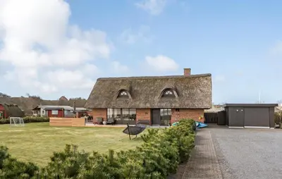 a brick house with a thatched roof at Amazing Home In Lemvig in Lemvig
