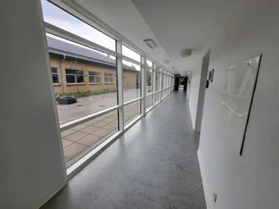 an empty hallway with large windows in a building at Jetsmark Idrætscenter in Pandrup