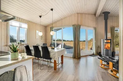 a dining room with a table and a fireplace at Beautiful Holiday Home With A Lovely View Of The Fjord And The Sea in Vestervig