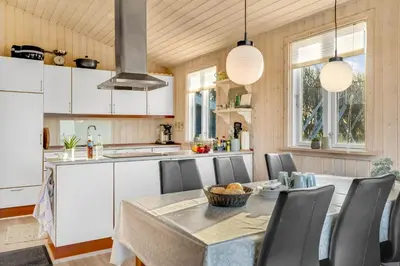 a kitchen with a table with chairs and a counter at Beautiful Holiday Home With A Lovely View Of The Fjord And The Sea in Vestervig