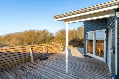 a wooden deck with awning on a house at Beautiful Holiday Home With A Lovely View Of The Fjord And The Sea in Vestervig