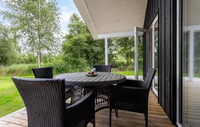 a patio with a table and chairs on a porch at 2 Bedroom Amazing Home In Hurup Thy in Sønder Ydby