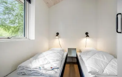 two beds in a room with a window at 2 Bedroom Amazing Home In Hurup Thy in Sønder Ydby