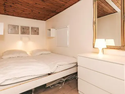 a white bedroom with a bed and a window at 6 person holiday home in Nibe in Nibe