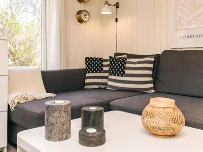a living room with a couch with pillows and a table at 6 person holiday home in Nibe in Nibe