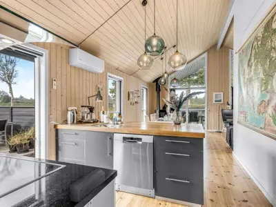 a kitchen with gray cabinets and a wooden ceiling at Holiday Home Carlina - 700m to the fjord by Interhome in Løgsted