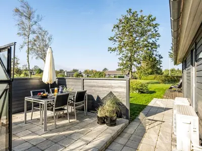 a backyard patio with a table and chairs at Holiday Home Carlina - 700m to the fjord by Interhome in Løgsted