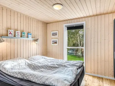 a bedroom with a bed in a room with a window at Holiday Home Carlina - 700m to the fjord by Interhome in Løgsted