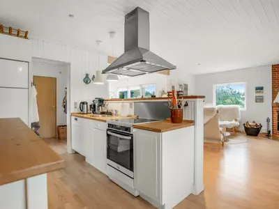 a kitchen with white cabinets and a stove top oven at Holiday Home Cate - 900m from the sea by Interhome in Saltum