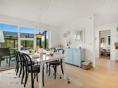 a kitchen and dining room with a table and chairs at Holiday Home Cate - 900m from the sea by Interhome in Saltum