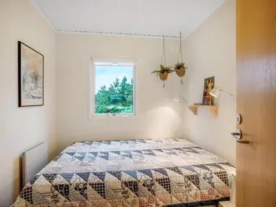 a bedroom with a bed with a quilt on it at Holiday Home Cate - 900m from the sea by Interhome in Saltum