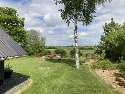 a garden with a tree in the grass at Holiday Home Adisl - 600m to the fjord by Interhome in Løgsted