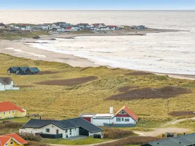a view of a beach with houses and the ocean at Holiday Home Amina - 50m from the sea by Interhome in Torsted
