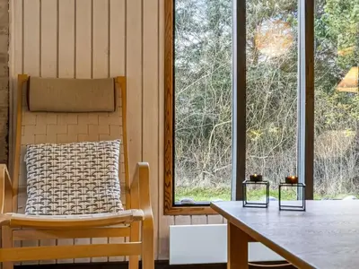 a room with a table and a chair and windows at Holiday Home Star - 600m from the sea by Interhome in Løkken