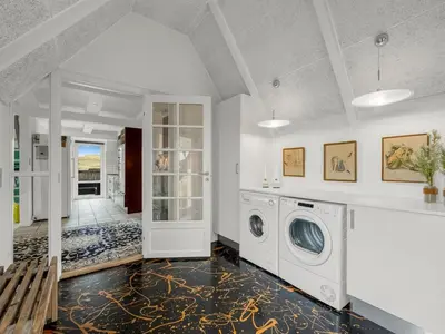a white laundry room with a washer and dryer at Holiday Home Kaja - 150m from the sea by Interhome in Harboør