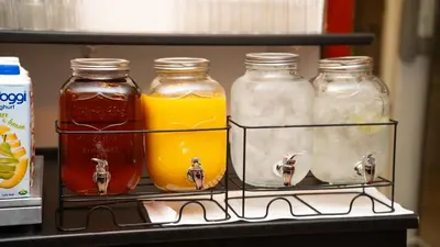 a shelf with four jars of honey and orange juice at Cityinn Hotel in Viborg