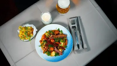 a table with a plate of food and a glass of beer at Cityinn Hotel in Viborg