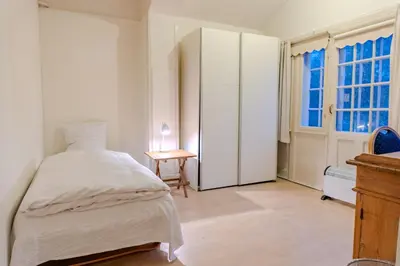 a bedroom with a bed and a dresser and a window at Villa Apartments Viborg in Viborg