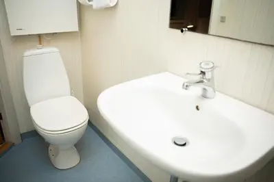 a bathroom with a white toilet and a sink at Villa Apartments Viborg in Viborg