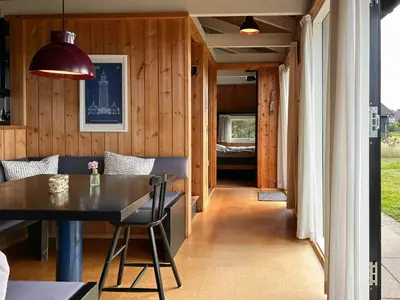 a dining room and living room with a table and chairs at Architect-Designed Summer House In Agger in Vestervig