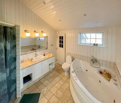 a bathroom with a tub and a toilet and a sink at Home With Sauna Near Klitmøller in Thisted