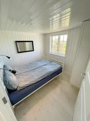 a bedroom with a bed in a white room at Home With Sauna Near Klitmøller in Thisted