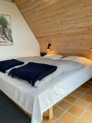 a large bed in a room with a wooden ceiling at Architect-Designed Gem At The West Coast in Pandrup