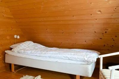 a bed in a room with a wooden wall at Nature Gem 5 Metres From Limfjord in Roslev