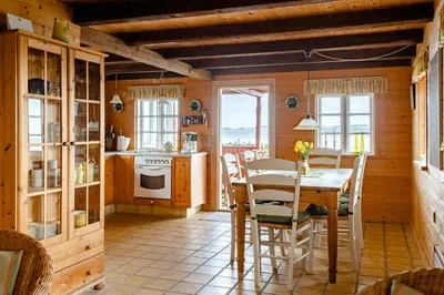 a kitchen with a table and chairs in a room at Nature Gem 5 Metres From Limfjord in Roslev