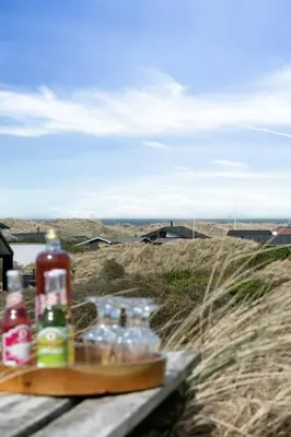 a group of bottles sitting on a table in a field at 70'S Style Summerhouse Near Løkken in Løkken