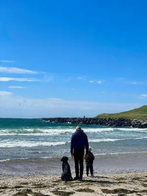 a man and a child and a dog on the beach at Cozy Summer House In Agger Near The North Sea in Vestervig