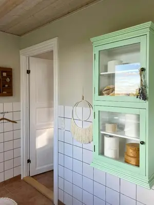 a green cabinet in a bathroom with white tiles at Summer House With Panoramic View Near Doverodde in Doverodde
