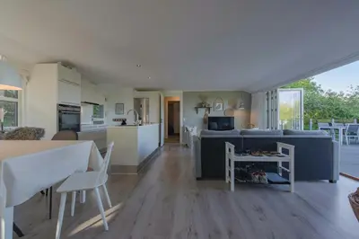 a living room and kitchen with a couch and a table at Panoramic View And Terrace In Charming Home in Højslev