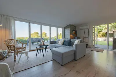 a living room with a couch and a table at Panoramic View And Terrace In Charming Home in Højslev