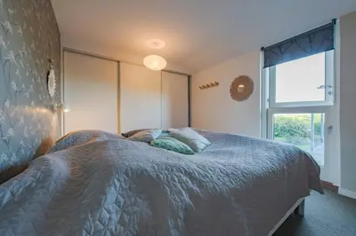 a bedroom with a bed with pillows and a window at Panoramic View And Terrace In Charming Home in Højslev