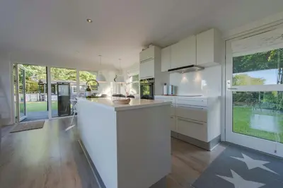 a kitchen with white cabinets and a large window at Panoramic View And Terrace In Charming Home in Højslev
