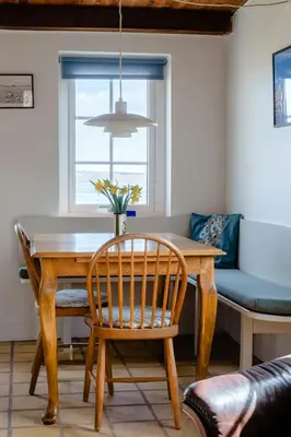 a dining room with a wooden table and a chair at Small House With View Of The Limfjord in Roslev