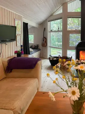 a living room with a couch and a table with flowers at Virksund Home With Grounds And Hot Tub in Højslev
