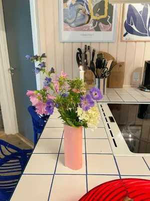 a pink vase with flowers on a kitchen counter at Virksund Home With Grounds And Hot Tub in Højslev