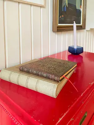 a book on top of a red dresser with a candle at Virksund Home With Grounds And Hot Tub in Højslev